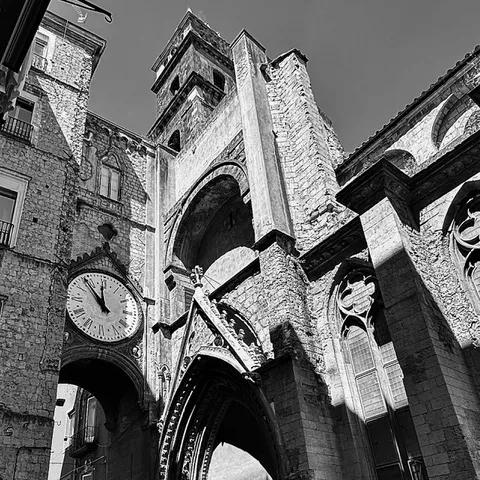 L'arco gotico con l'orologio e il campanile di Sant'Eligio Maggiore, ripresi dal basso in controluce, in bianco e nero