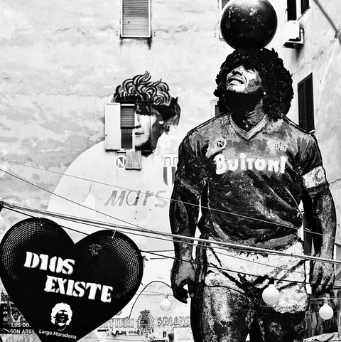 Largo Maradona nei Quartieri Spagnoli: la statua del calciatore con il pallone sulla testa, il cuore nero con la scritta «Dios existe» e i murales intorno, in bianco e nero