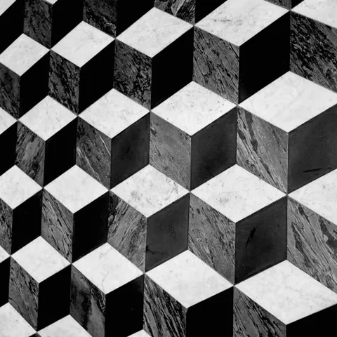 Tarsie di marmo compongono un motivo geometrico di cubi tridimensionali dall'effetto illusorio, in bianco e nero