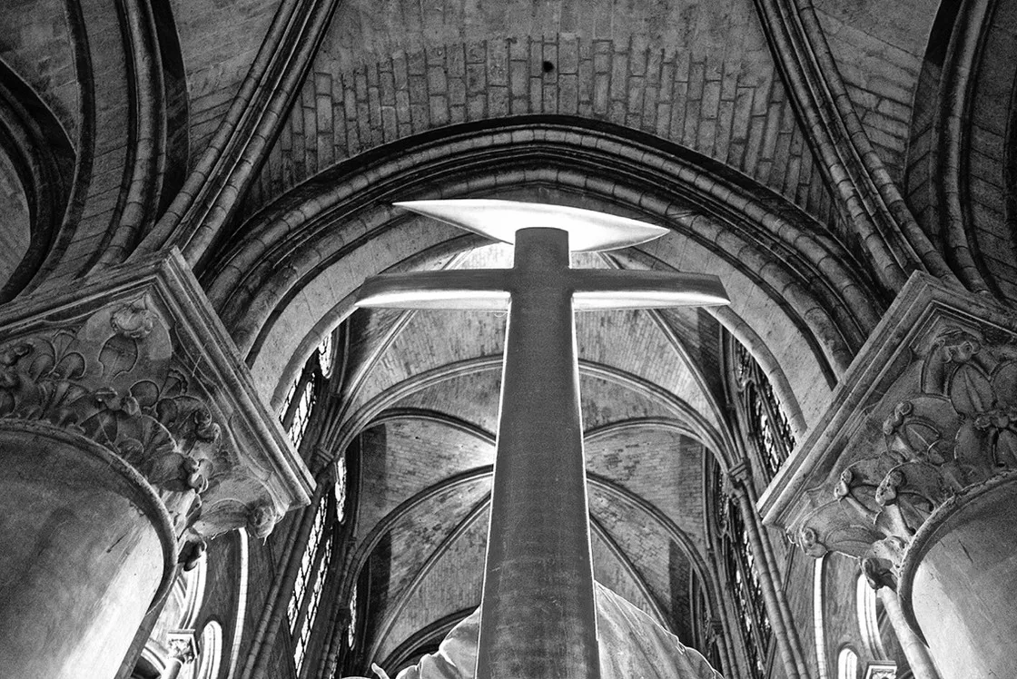 Interno di una cattedrale gotica visto dal basso, alta croce e volte a crociera, in bianco e nero